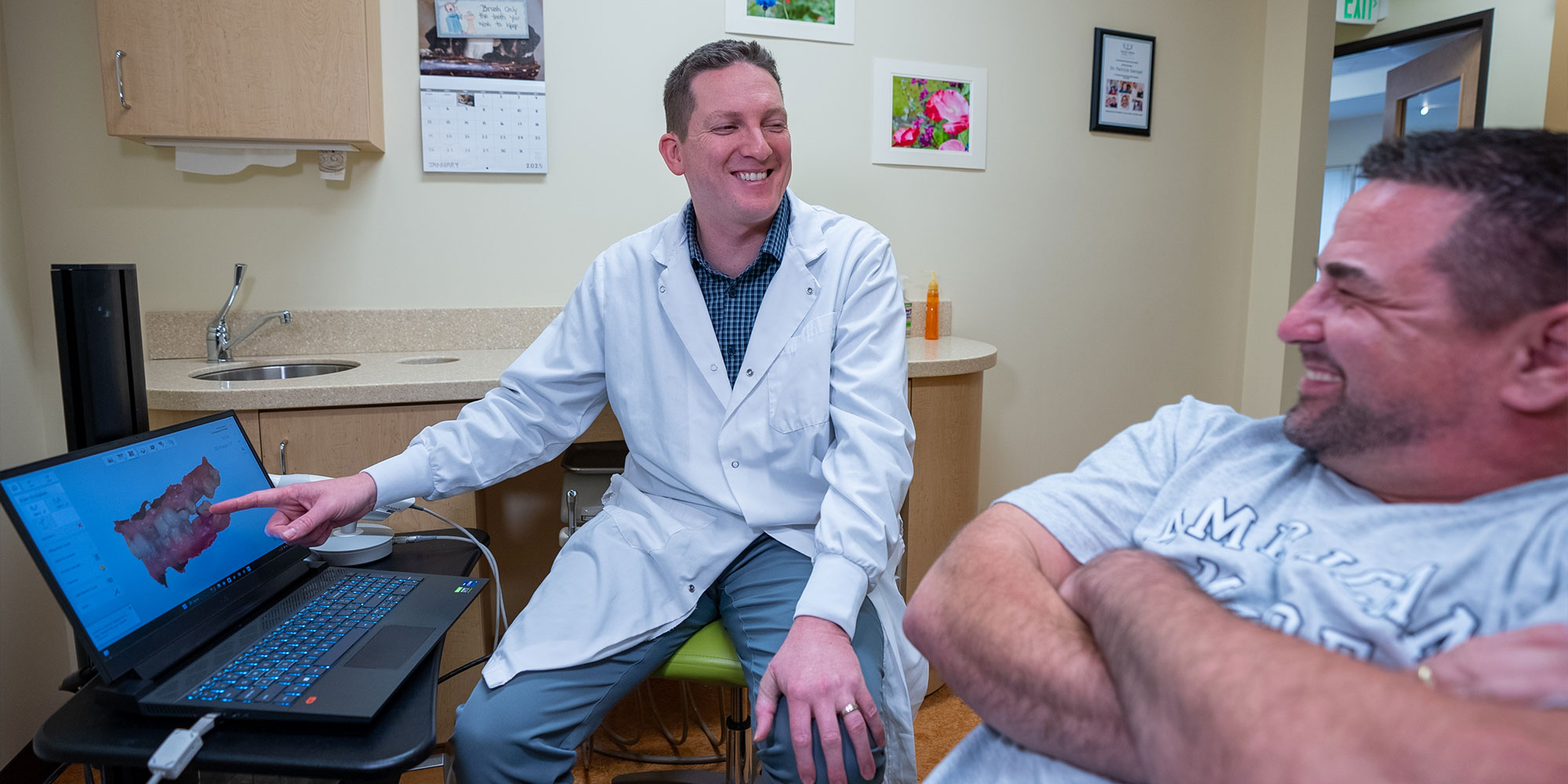 doctor going over 3d scan of patients teeth with the patient